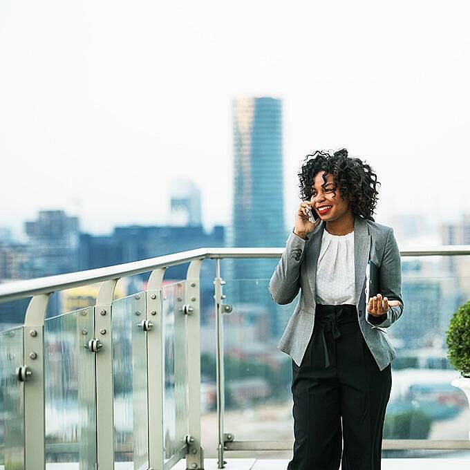 Woman standing on a roof terrace and talking on the phone